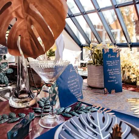 Mise en scène sur table de fête du menu fougères pour mariage bleu marine et cuivre