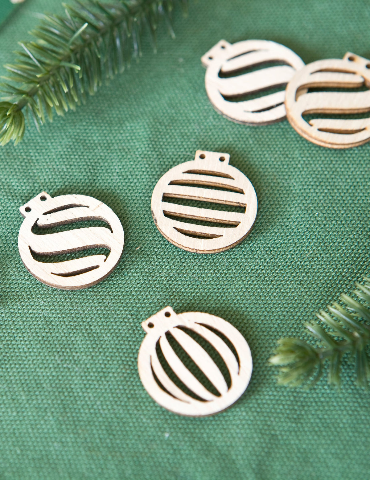 Gros plan sur les motifs des confettis boules de Noël pour décoration de table en bois ajouré