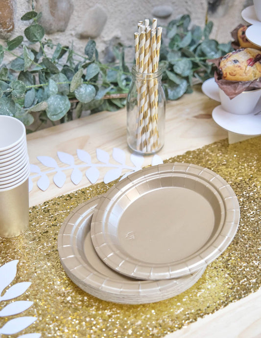 Mise en scène sur une table des petites assiettes en carton pour fête doré mat