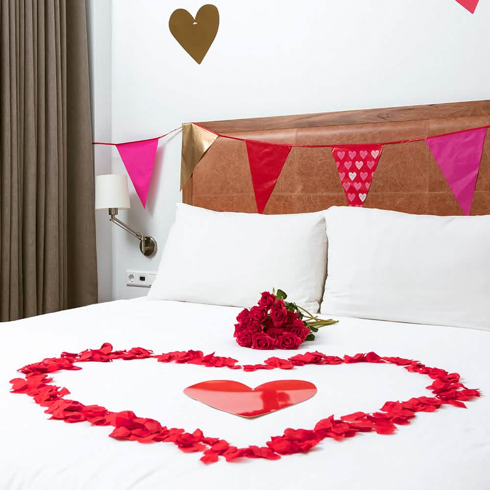 Inimă formată pe un pat de petale de roz pentru decor de petrecere