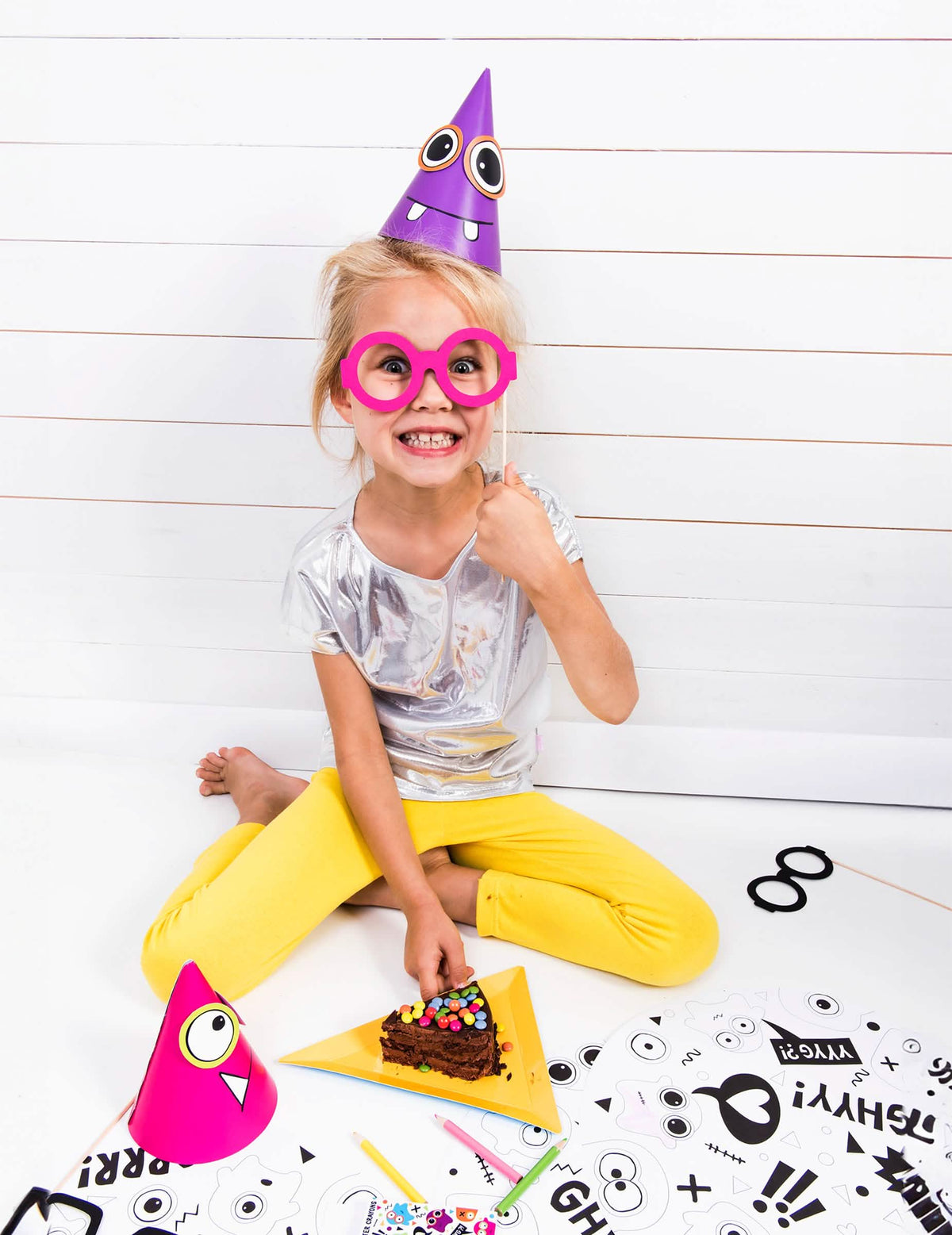 Enfant portant le chapeau violet du chapeaux de fête petits monstres
