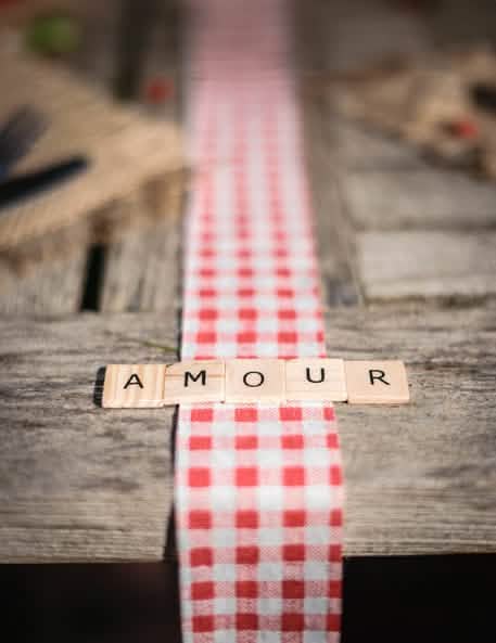 Cuvântul AMOUR pe un șervet de masă în carouri, cu 60 de litere alfabet tip scrabble, pentru decorațiuni de masă din lemn