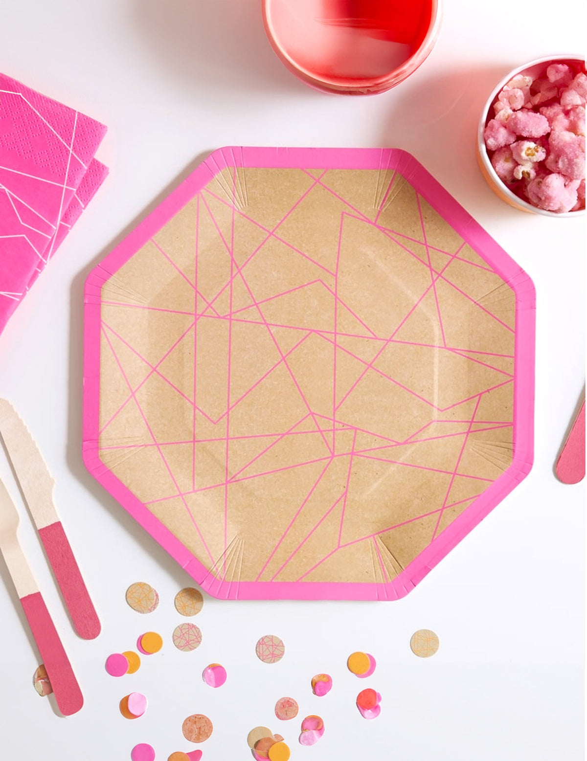 Vue de dessus des assiettes en carton kraft géométrique pour fête rose néon octogonales
