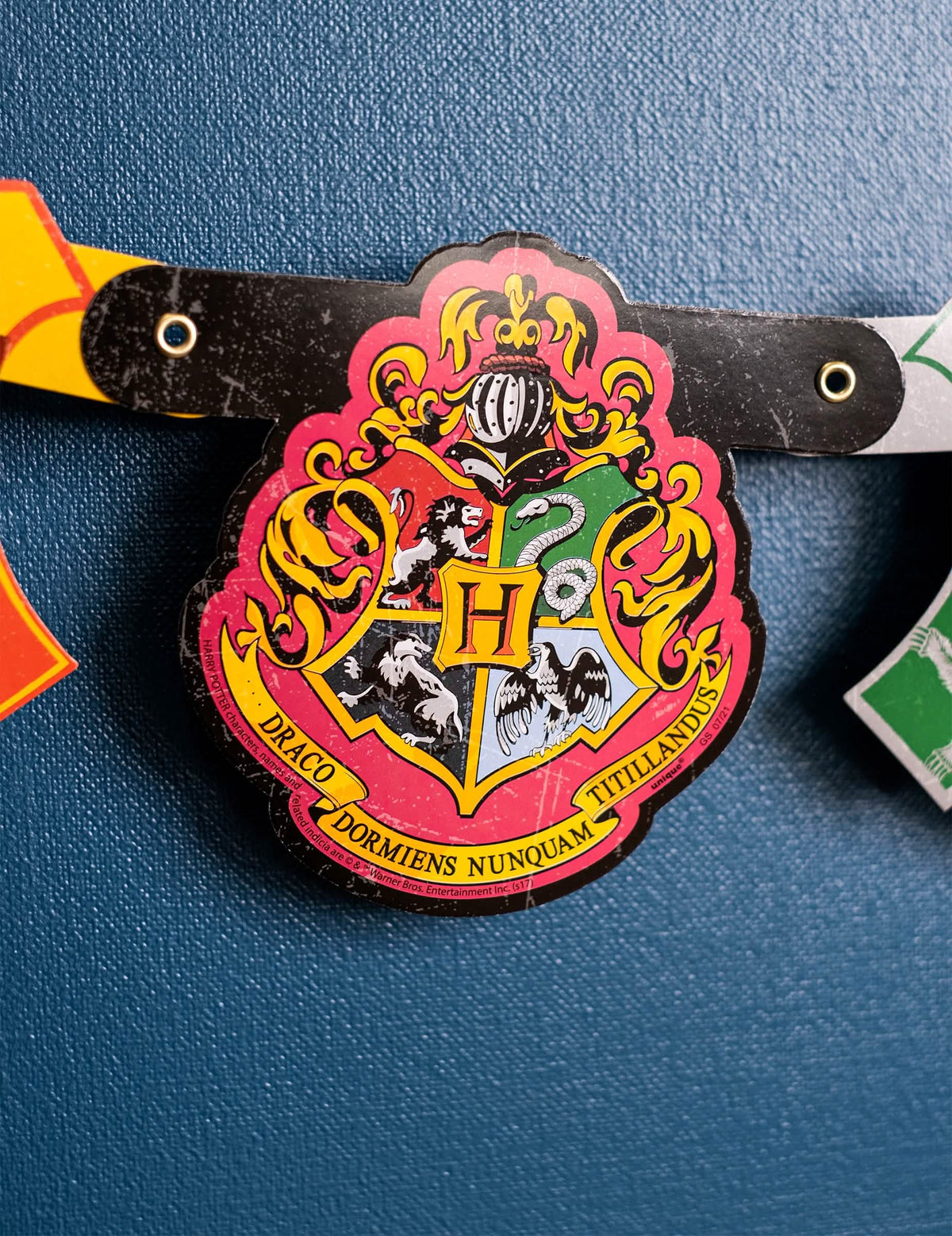 Prim-plan asupra stemei de la Hogwarts de pe bannerul happy birthday Harry Potter