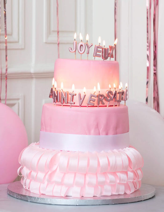 Mise en situation sur un gâteau des bougies sur pic joyeux anniversaire rose gold métallisé