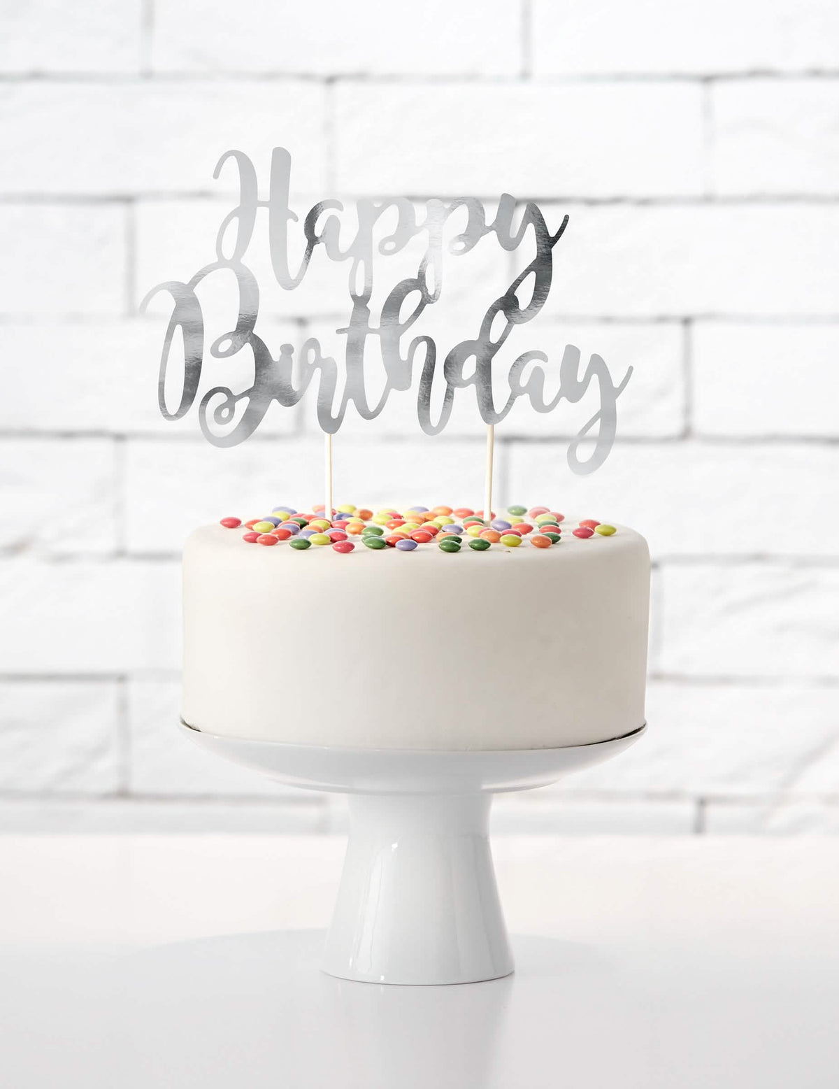 Vedere de ansamblu asupra unui tort cu cake topper happy birthday argintiu metalizat