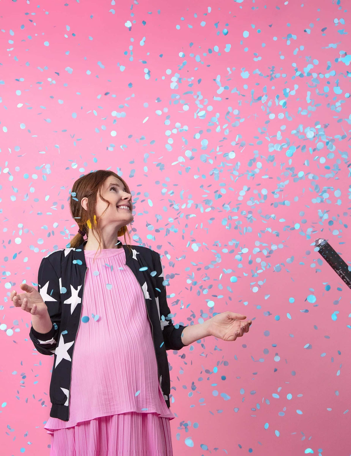 Ploaie de confetti albastre peste o femeie însărcinată din tunul cu confetti boy pentru baby shower