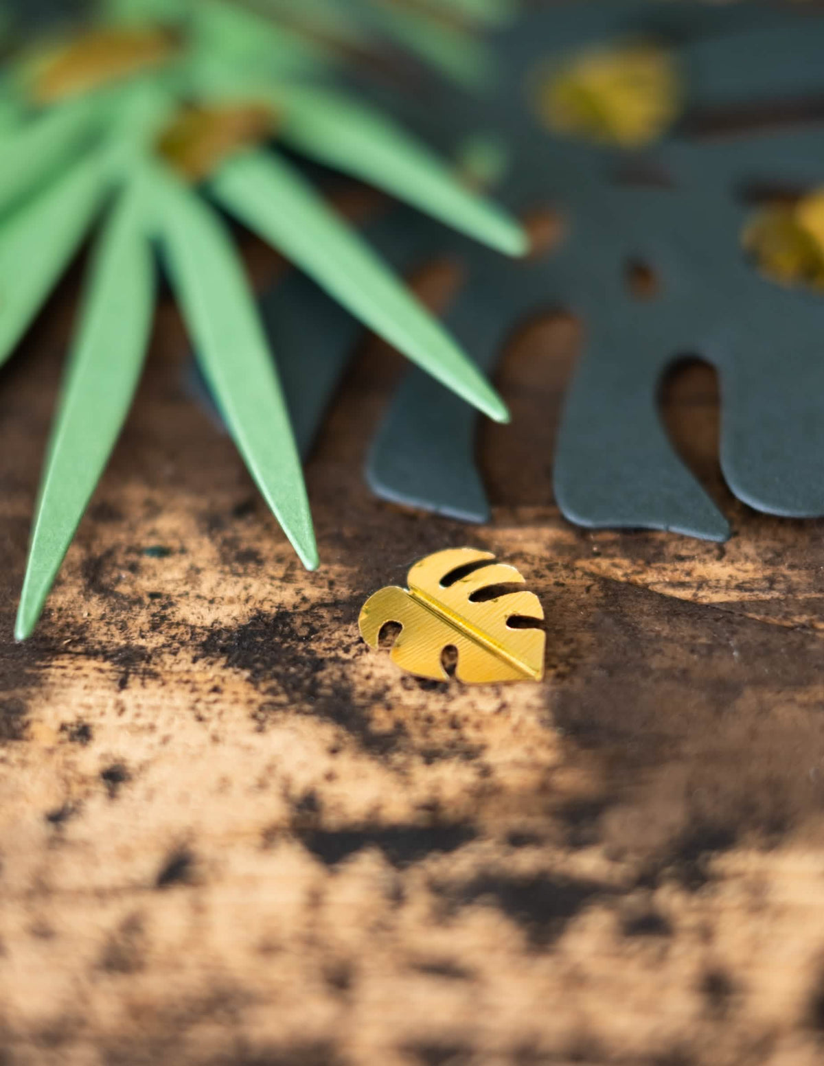 Prim-plan al unei frunze aurii de monstera din confetti de masă frunze tropicale