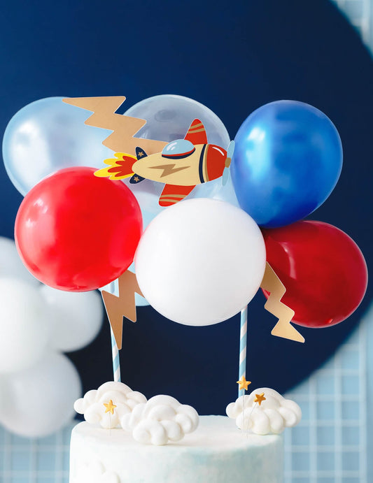 Gros plan sur l'avion et les ballons de la décoration de gâteau petit avion