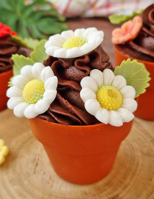 Gros plan des décorations en sucre marguerites et feuilles blanches et vertes