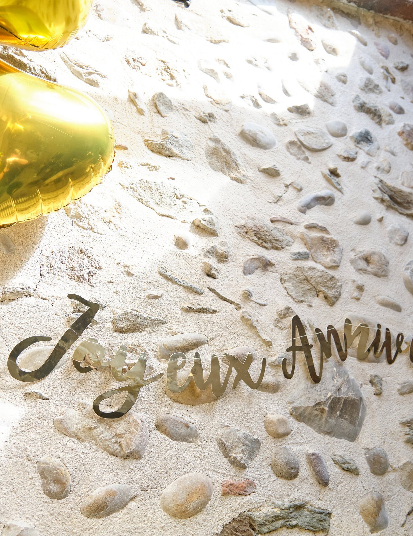 Gros plan sur le lettrage de la Guirlande Joyeux Anniversaire métallisée dorée