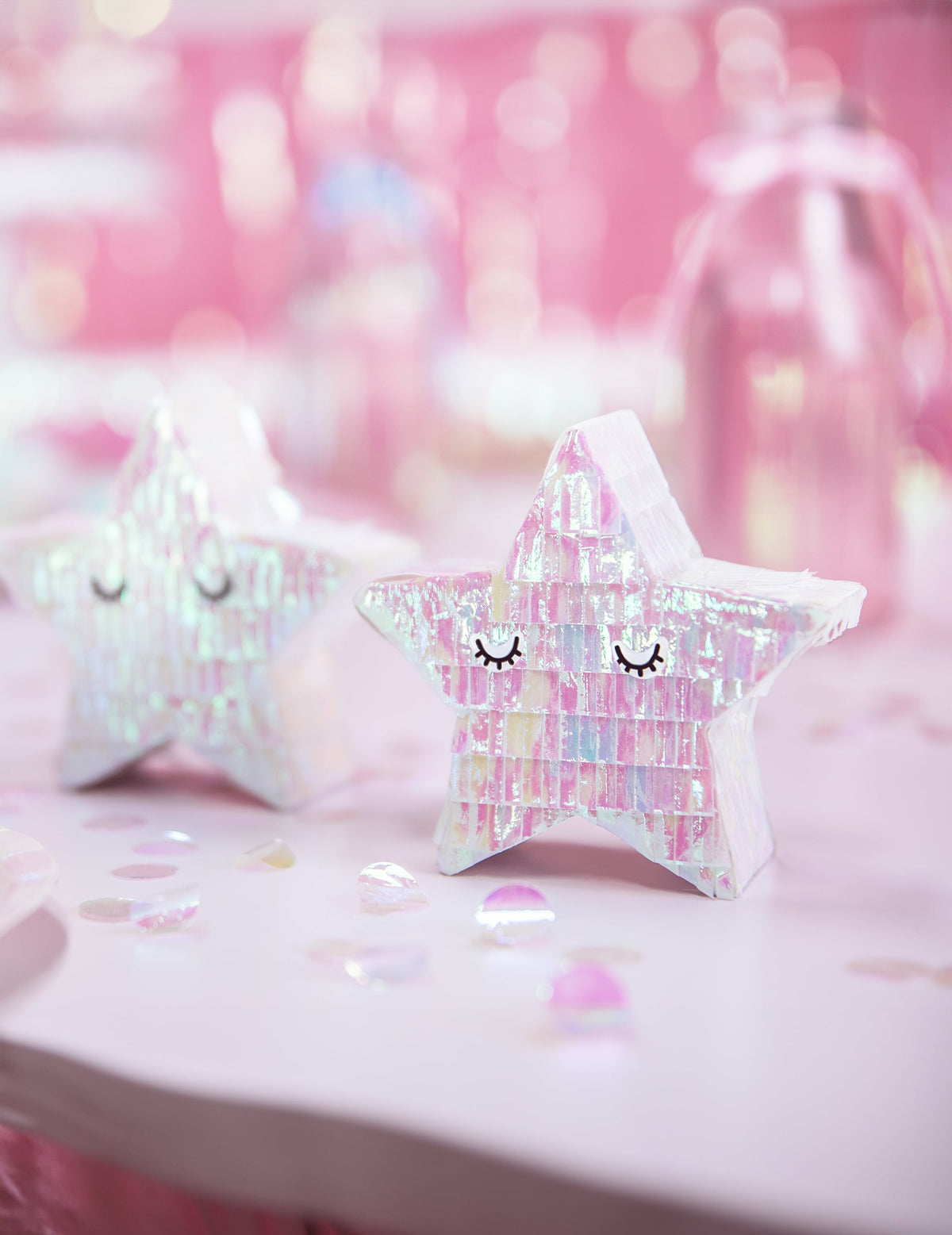 Prim-plan pe fundal roz al mini piñatei stea pentru decorațiune iridescentă