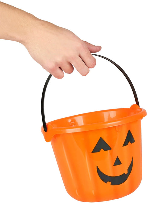 Detaliu al mânerului ținut de o mână al găleții dovleac pentru halloween