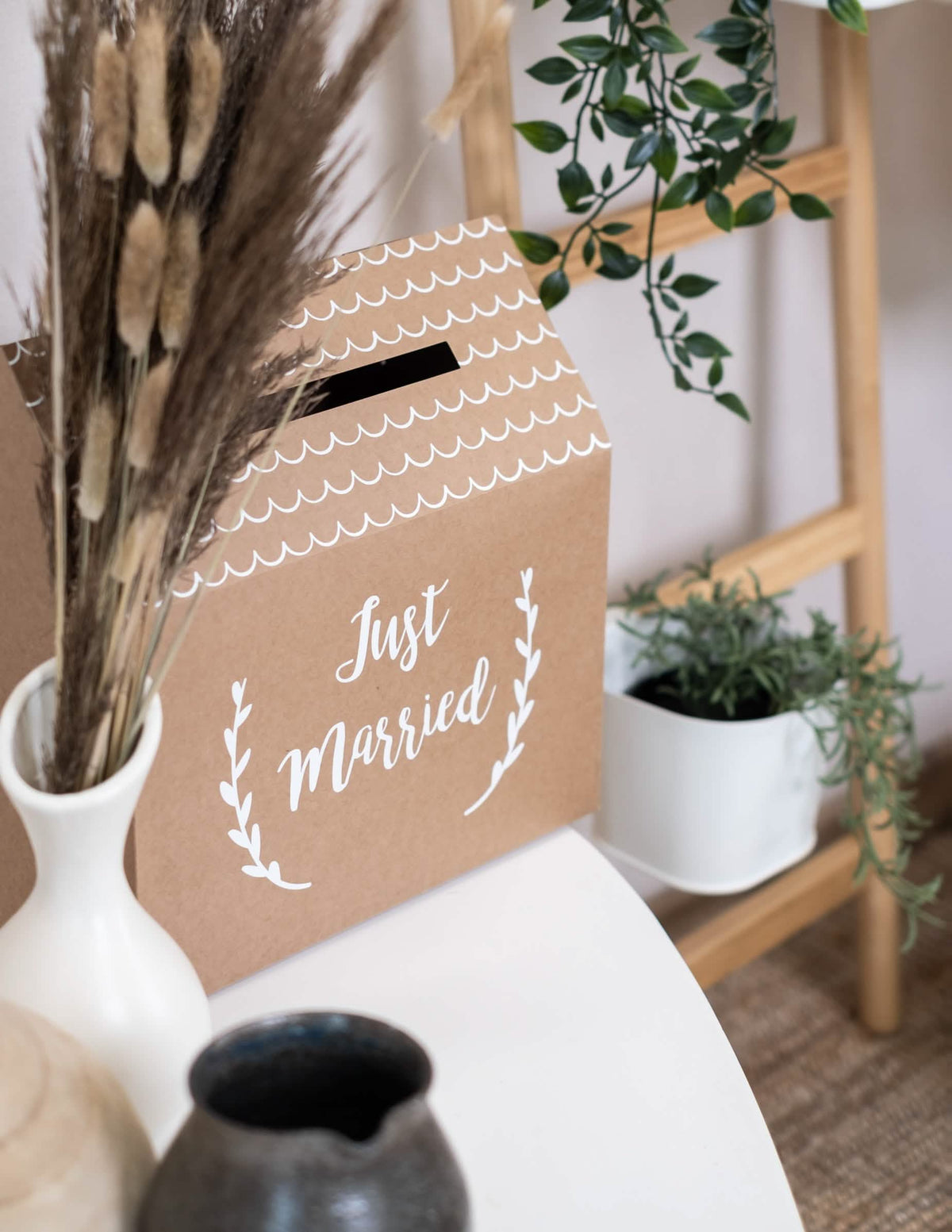 Vedere din trei sferturi a urnei din carton kraft Just Married în formă de casă