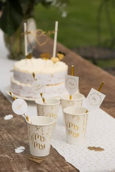 Aranjare pe o masă cu pahare din carton Just Married pentru nuntă