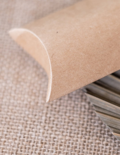 Détail de la fermeture incurvée des petites boîtes kraft pour fête marron clair en forme de berlingot