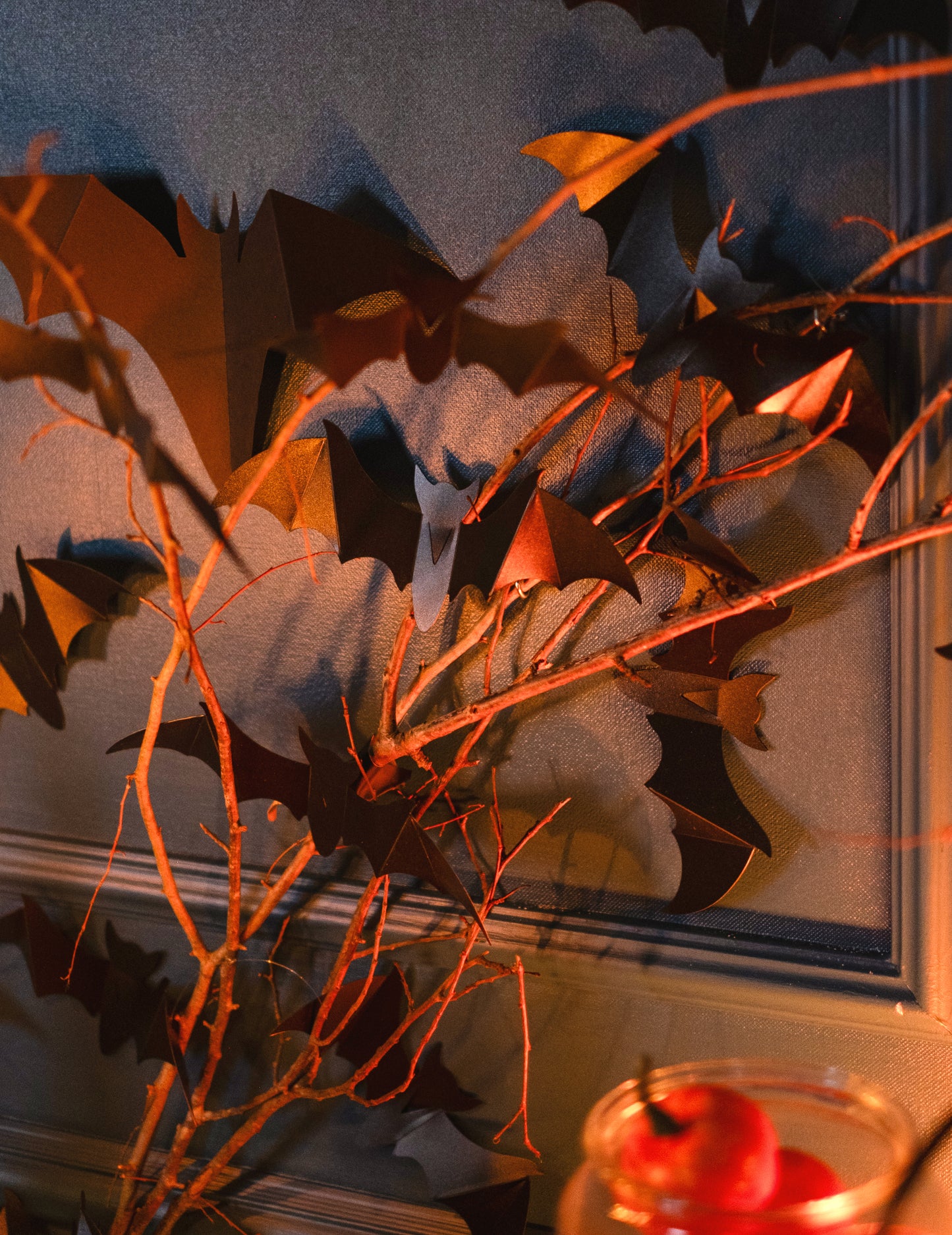 Vue rapprochée de la mise en scène sur branches du lot de 12 chauve-souris murales décoratives pour Halloween