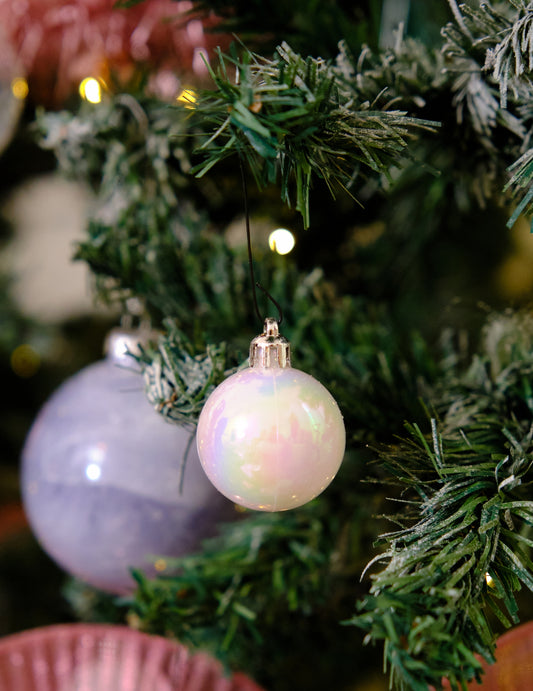 Mise en situation dans un sapin du lot de 18 mini boules de Noël blanches pailletées et mates