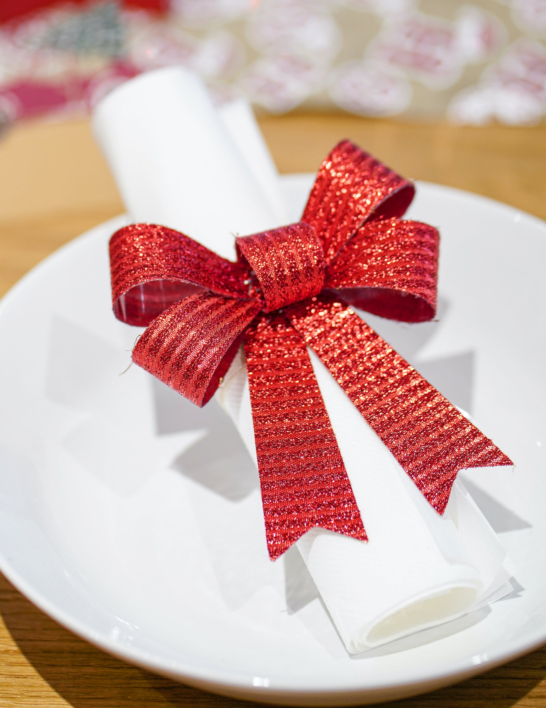 Mise en situation sur une serviette des nœuds pour décoration rouges et brillants