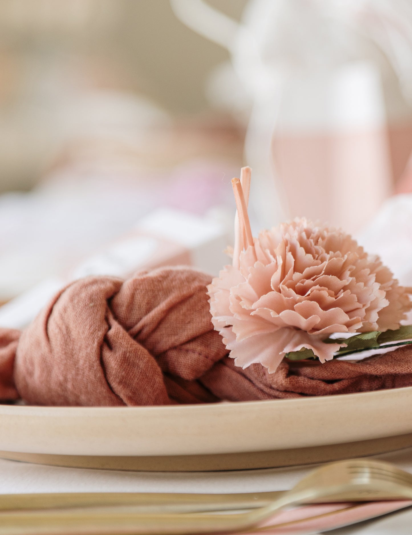Détail de la fleur sur une serviette nouée des fleurs artificielles de pivoines pour décoration
