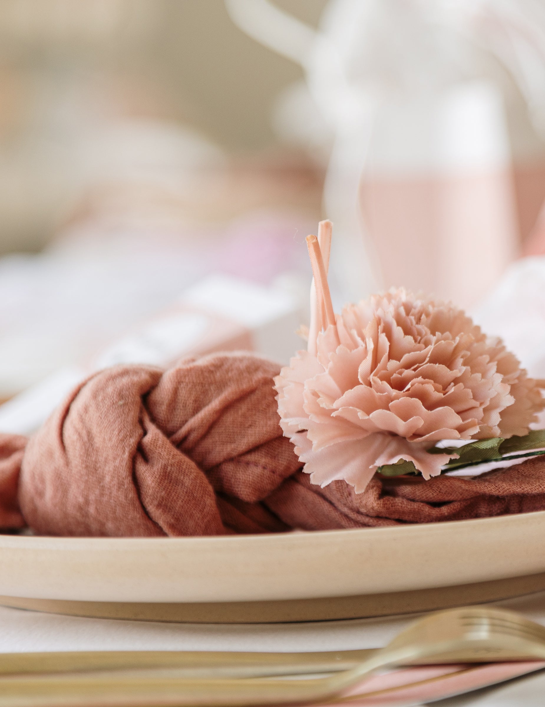 Détail de la fleur sur une serviette nouée des fleurs artificielles de pivoines pour décoration