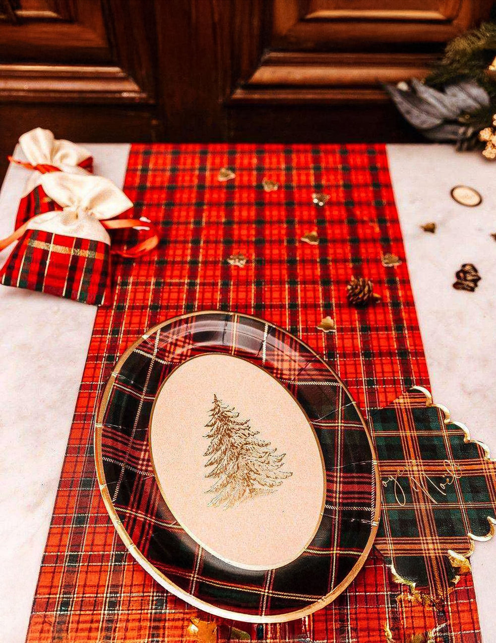 Mise en scène avec décoration de fête et pochons du plateaux en carton tartan de Noël