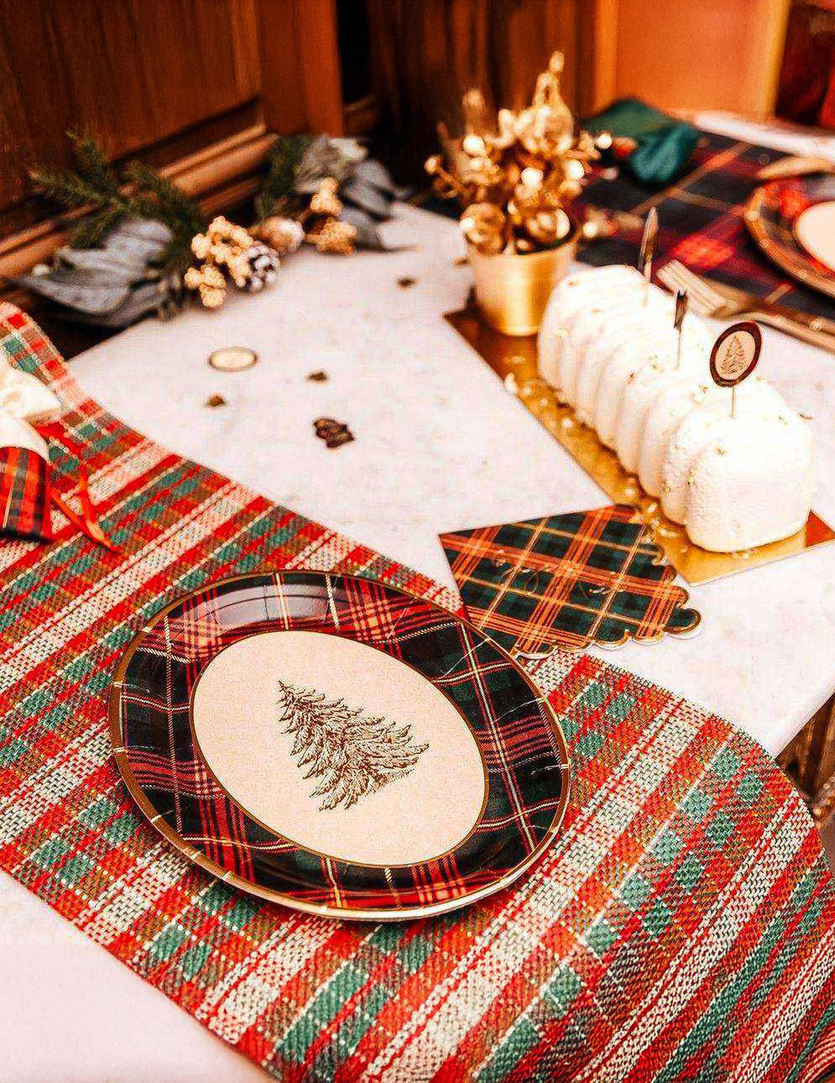Mise en scène avec bûche de Noël du plateaux en carton tartan de Noël