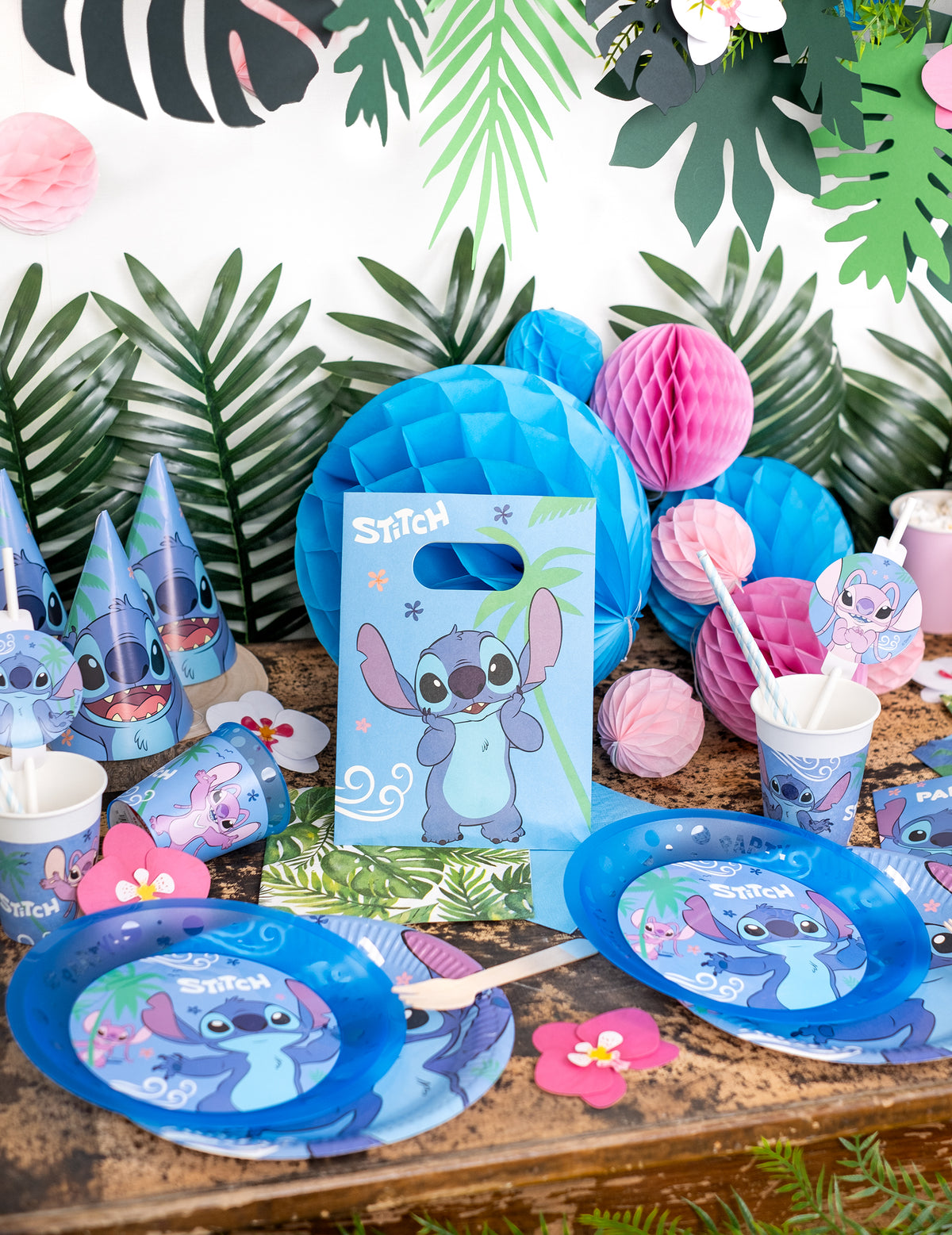 Mise en situation sur une table de fête des sacs cadeaux en papier Stitch