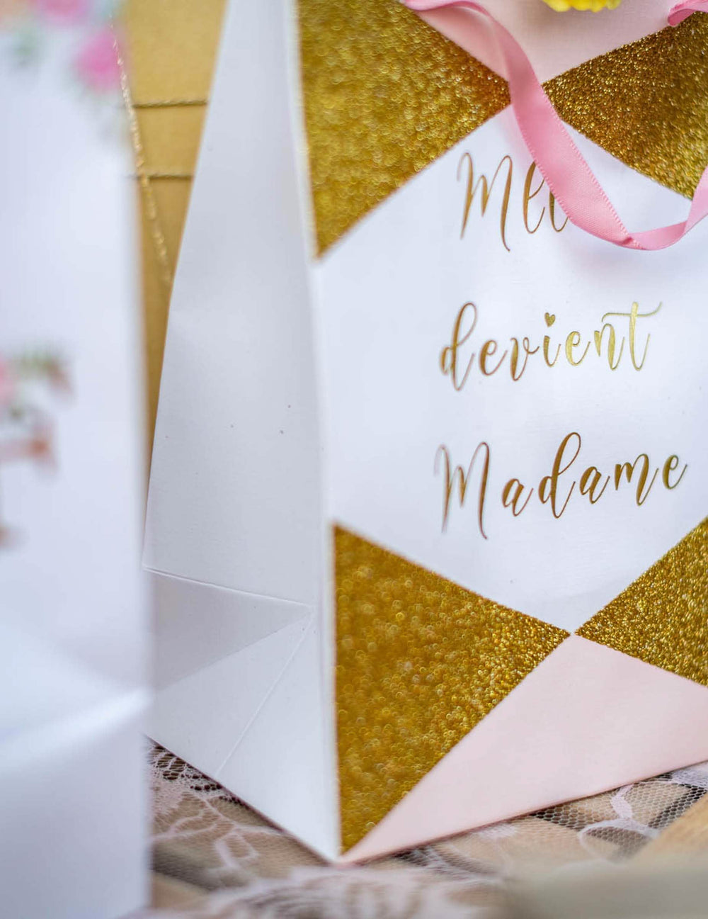 Gros plan sur les détails pailletés et l'inscription du sac en carton Mlle devient madame pour future mariée