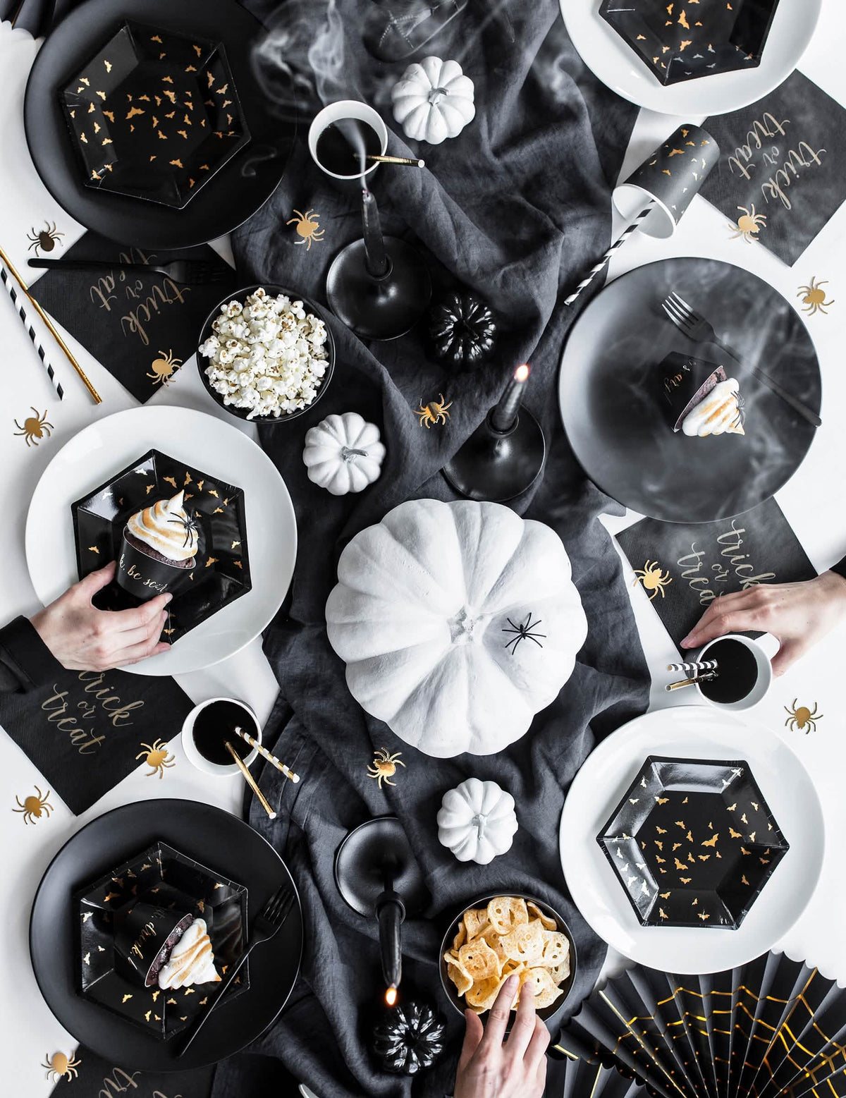 Vedere de sus a decorațiunilor de masă ale farfuriilor din carton cu lilieci negri și aurii, hexagonale