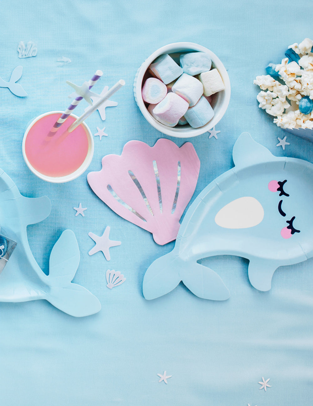 Mise en situation sur une table de fête des assiettes en carton licorne des mers narval bleue