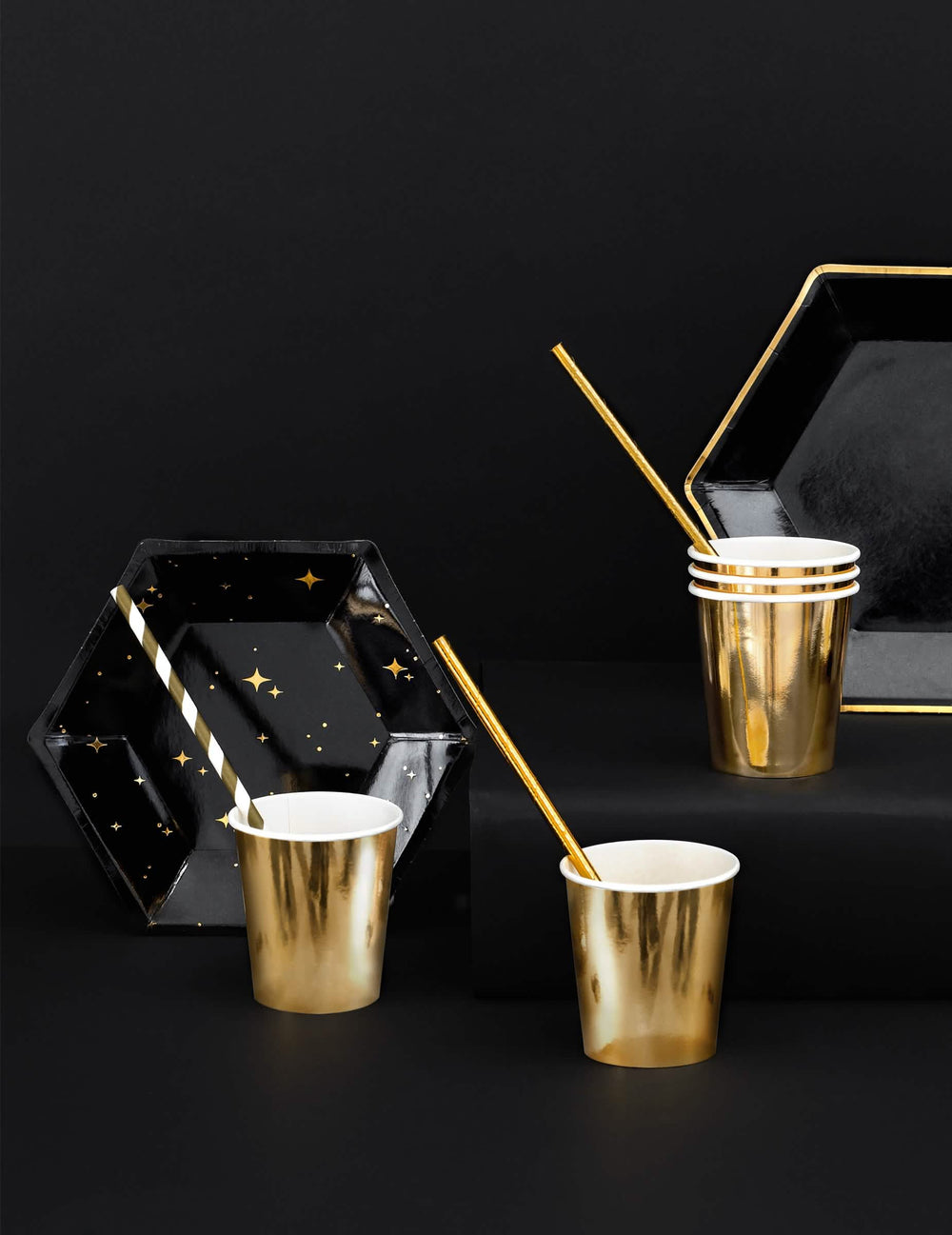 Așezarea farfurii de carton hexagonale cu stele pentru petrecere, negre și aurii