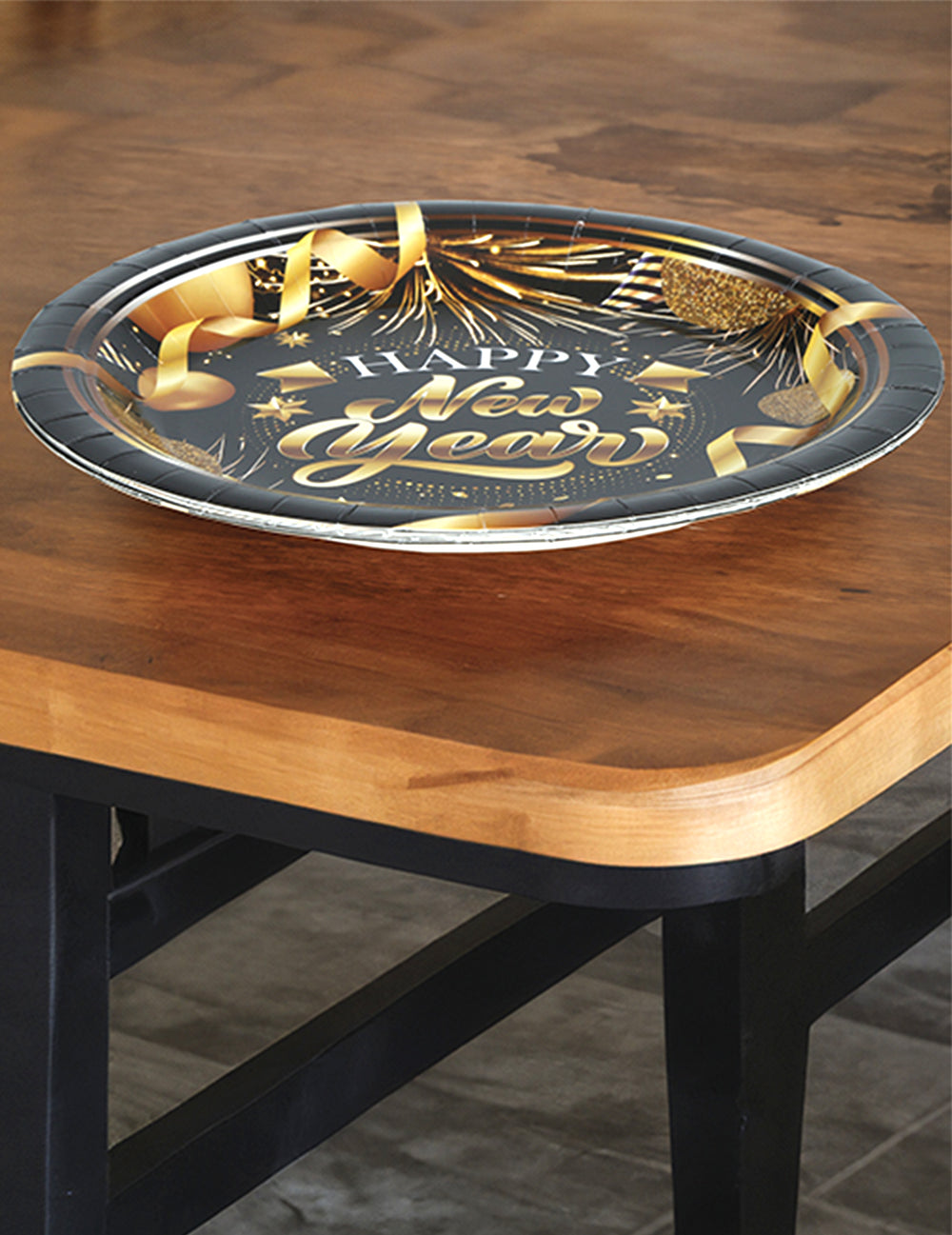 Vue rapprochée sur table des assiettes en carton Happy new year noir et or
