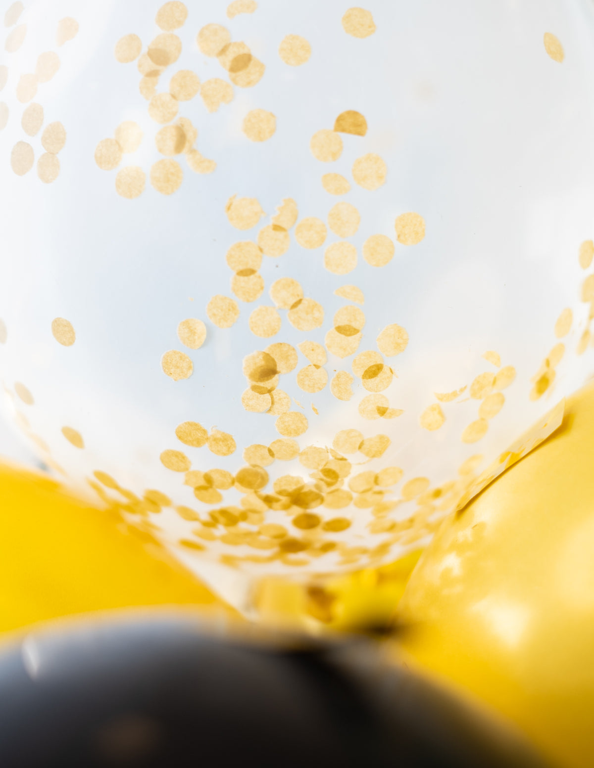Détail des confettis à l'intérieur des ballons en latex avec confettis transparents ocre doré