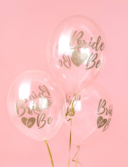 Gros plan sur l'inscription dorée des ballons transparents bride to be pour décoration evjf