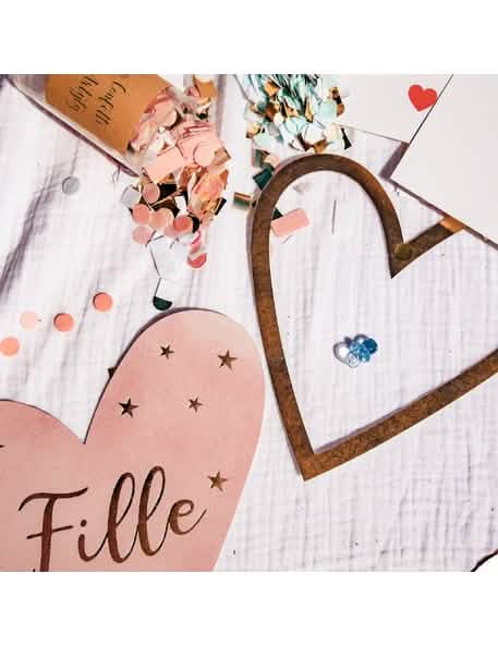 Detaliu al inimii roz și al confettiilor din decorațiunile de masă pentru fată sau băiat pentru gender reveal