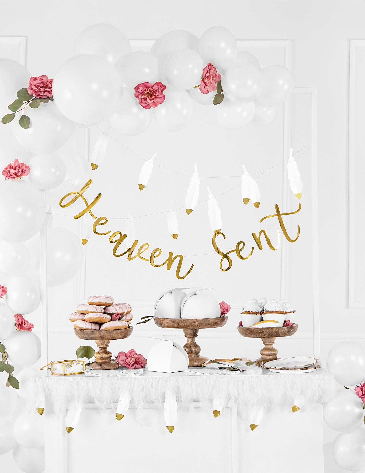Mise en scène avec ballons et bannière des habillages à cupcakes en papier pour mariage