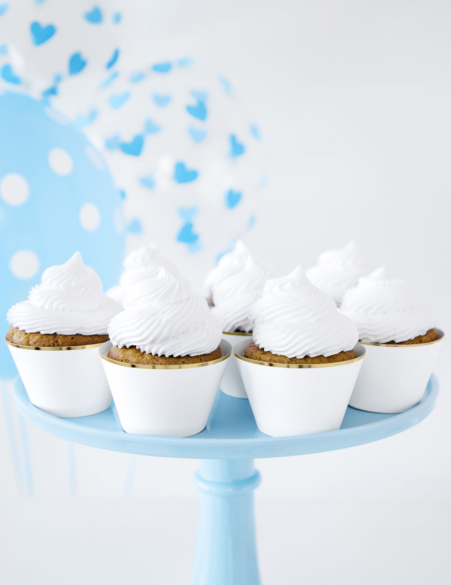 Mise en scène avec ballons bleus des habillages à cupcakes en papier pour mariage