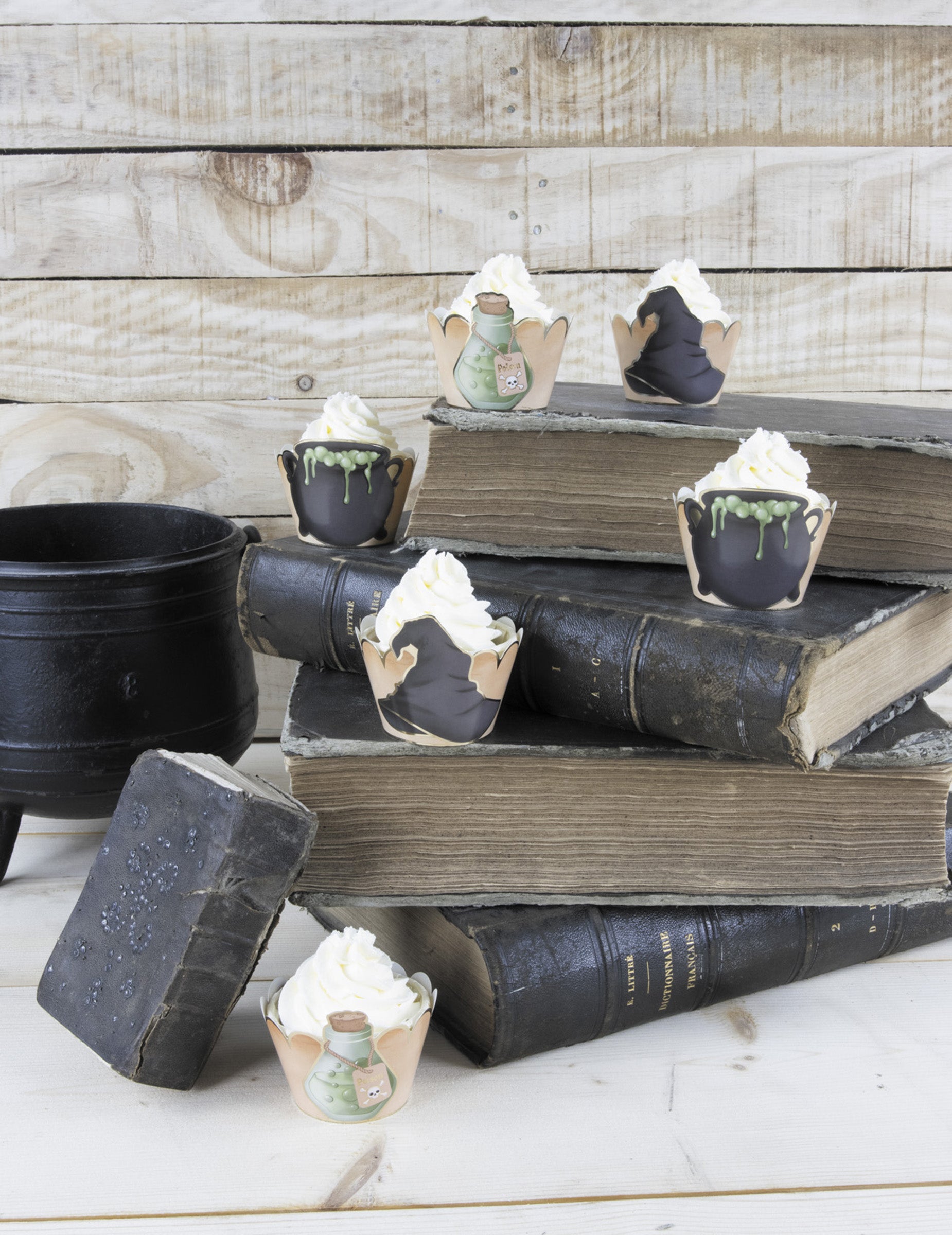 Mise en scène sur des livres anciens des habillages moules à cupcake apprenti sorcier