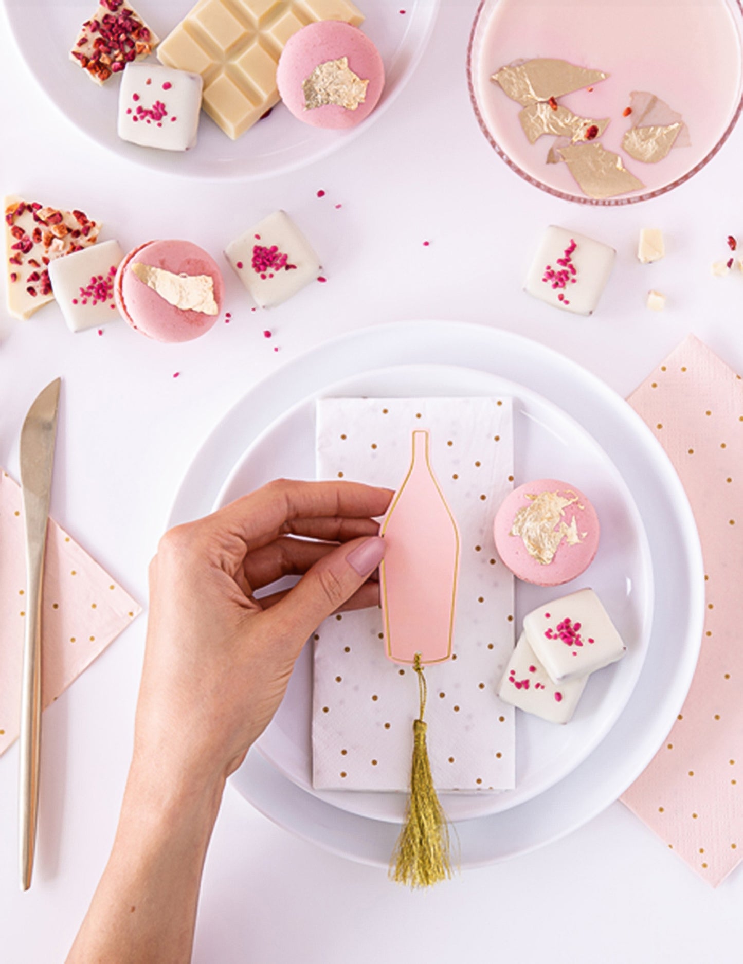 Mise en situation du marque-places bouteille pour fête rose et doré avec tassel doré