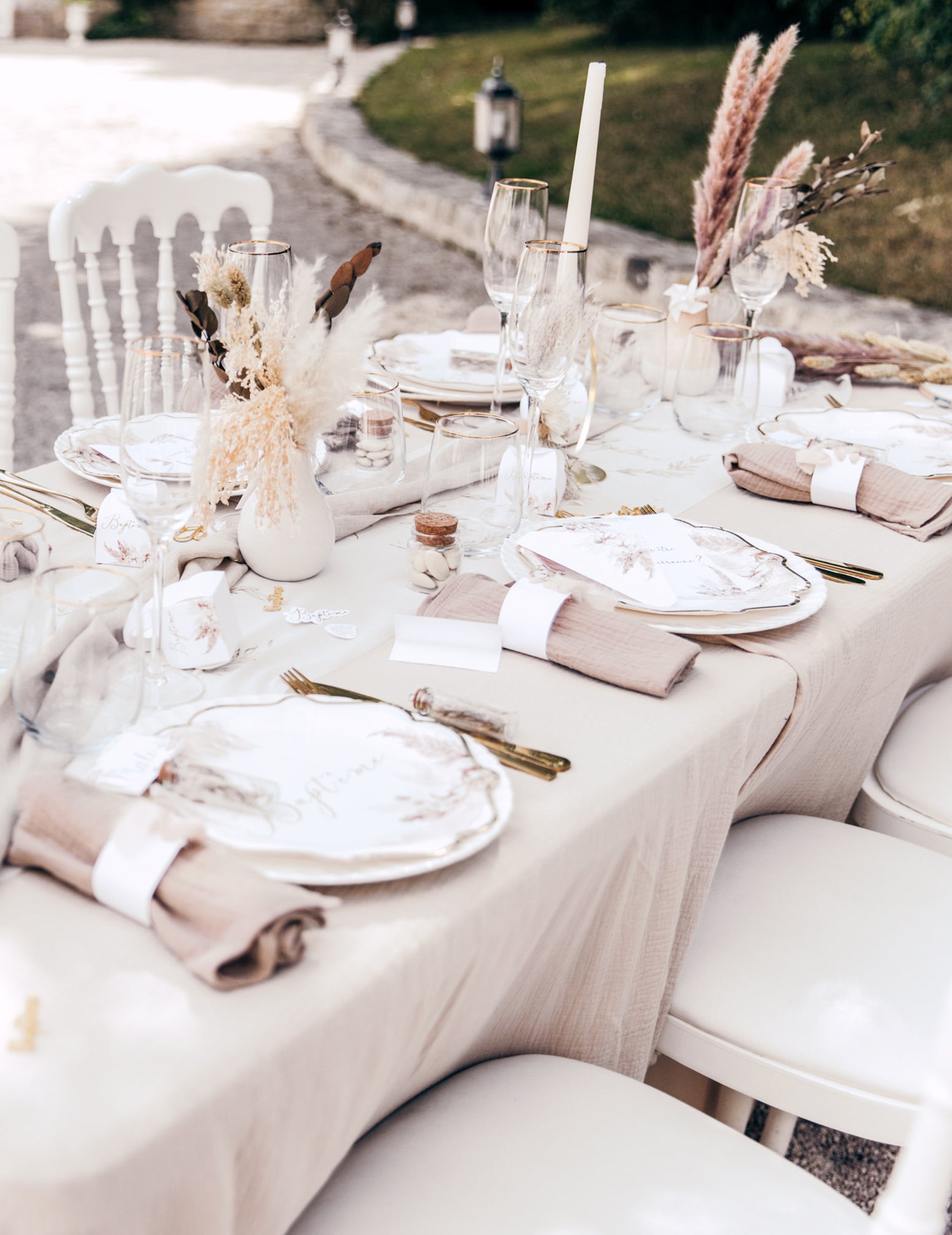 Vue d'ensemble de la table avec les assiettes baptême pampas et fleurs de coton