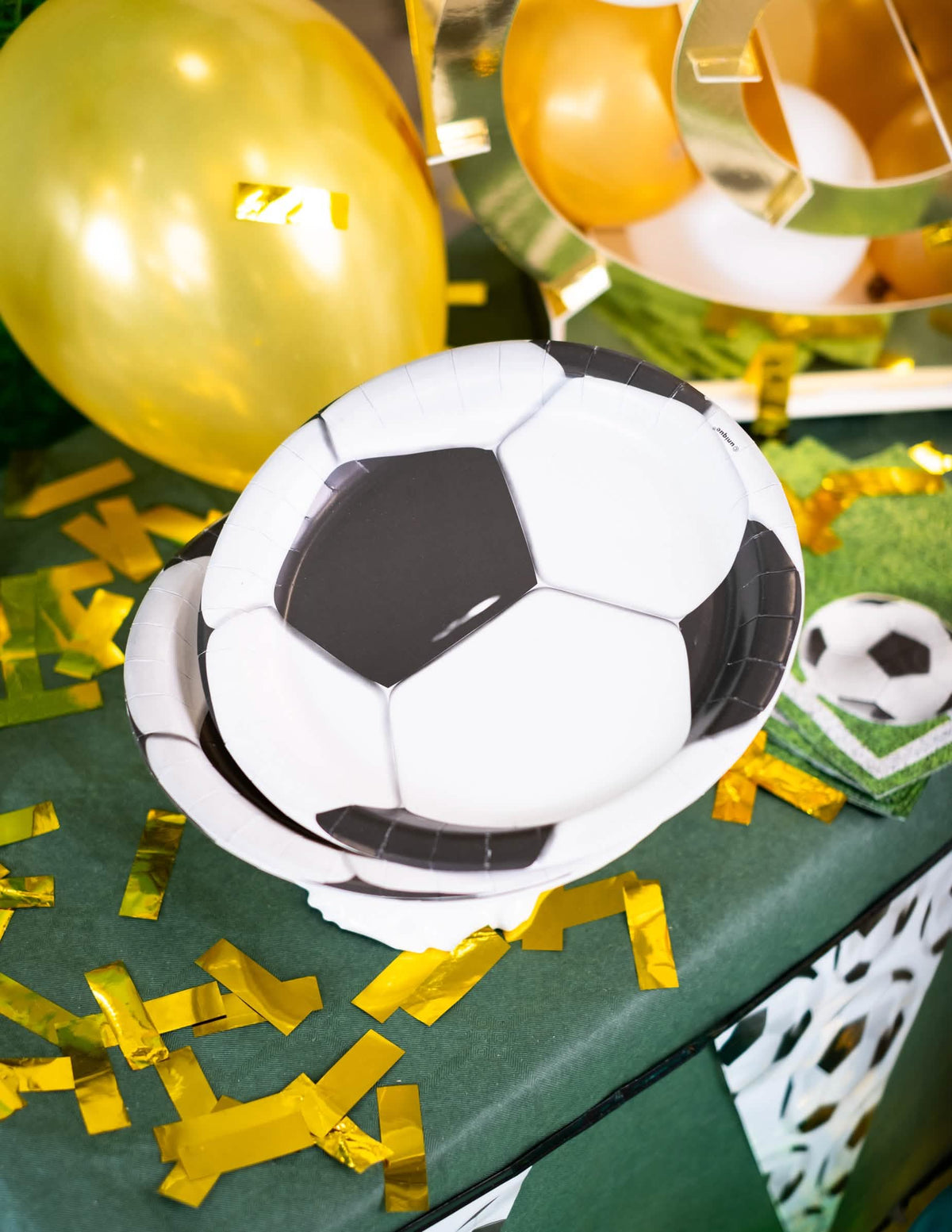 Sărbătoare pe o masă de petrecere cu farfurii din carton cu fotbal
