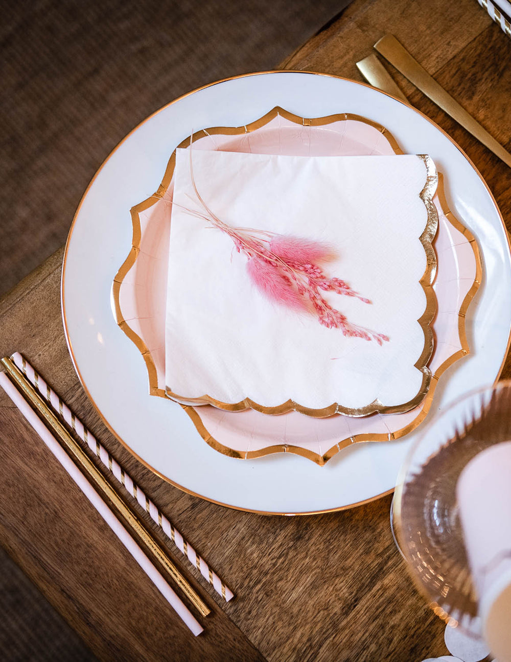Détail des bords dorés festonnés des assiettes en carton rose poudré pour fête avec bordures dorées