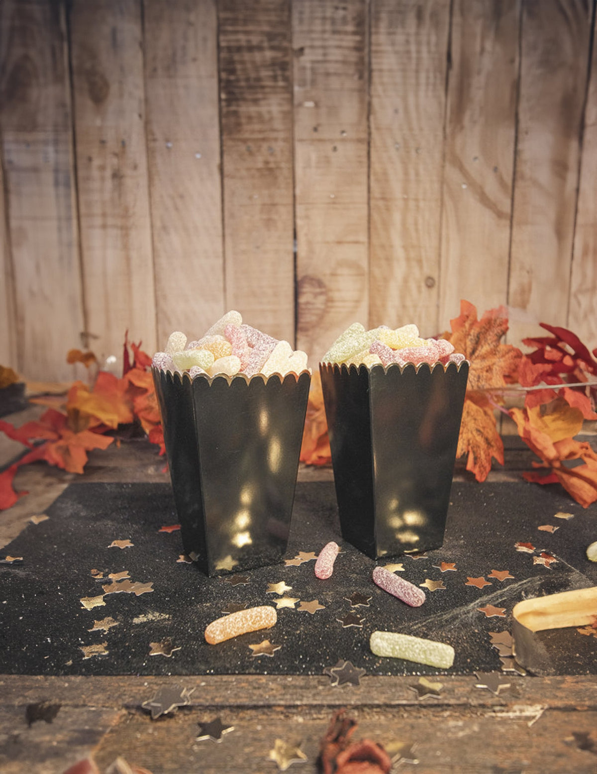 Mise en situation automnale avec bonbons des boîtes à pop-corn festonnées pour fête noires et or