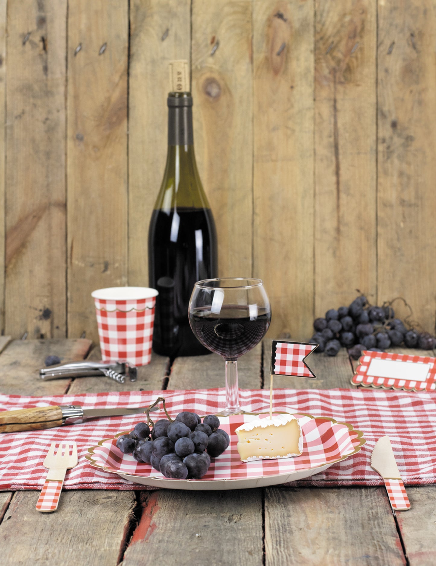 Mise en situation sur une table des fourchettes en bois vichy pour fête rouge et doré