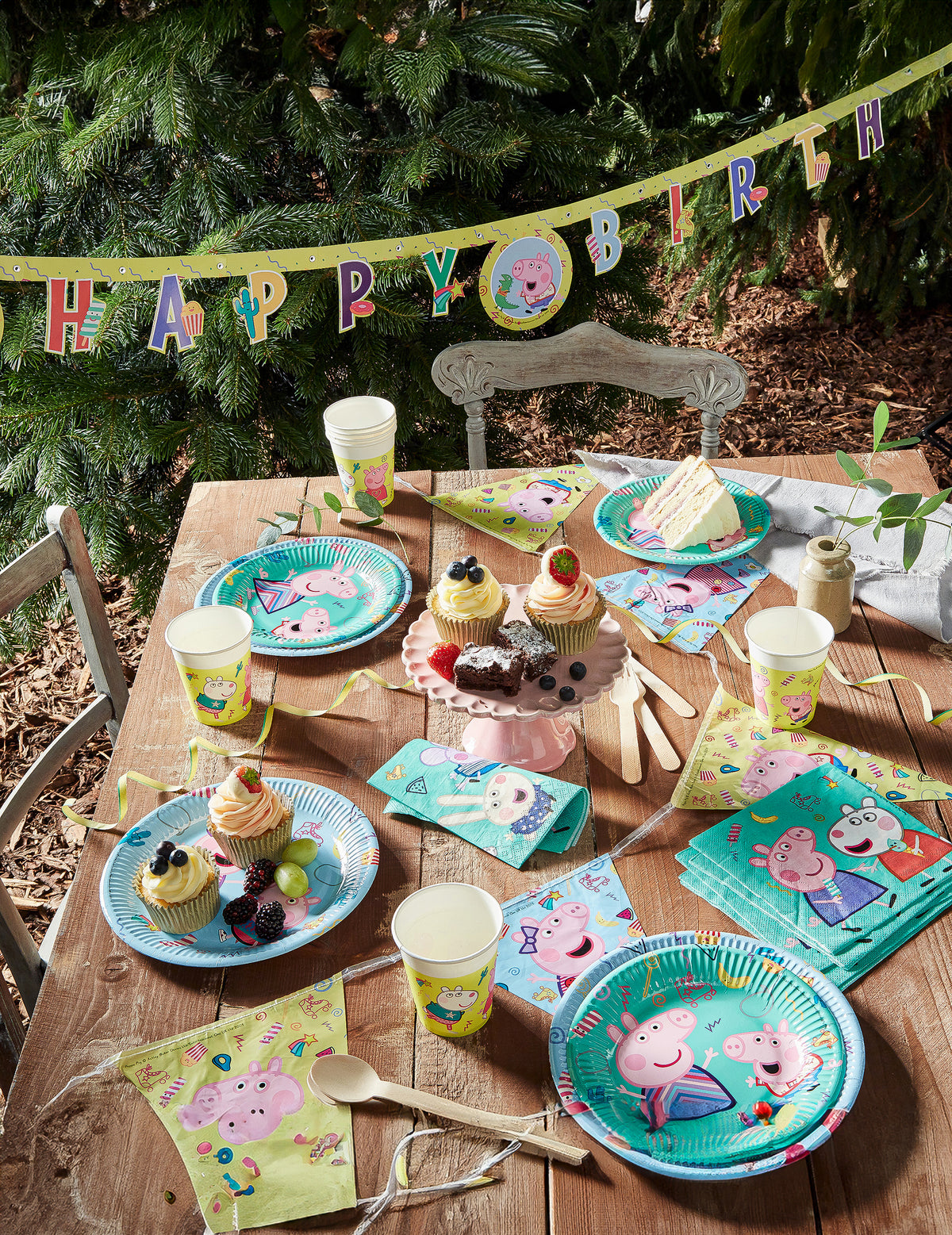 Vue d'ensemble de la table de fête avec guirlande des gobelets en carton Peppa Pig
