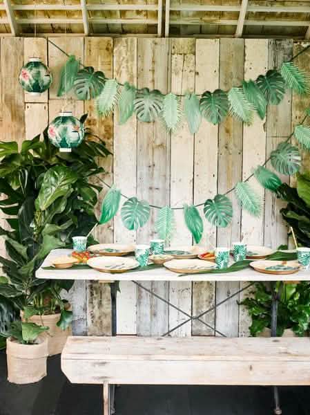 Aranjare pe o masă a unor pahare din carton tropical verde cu motive de frunze de palmier