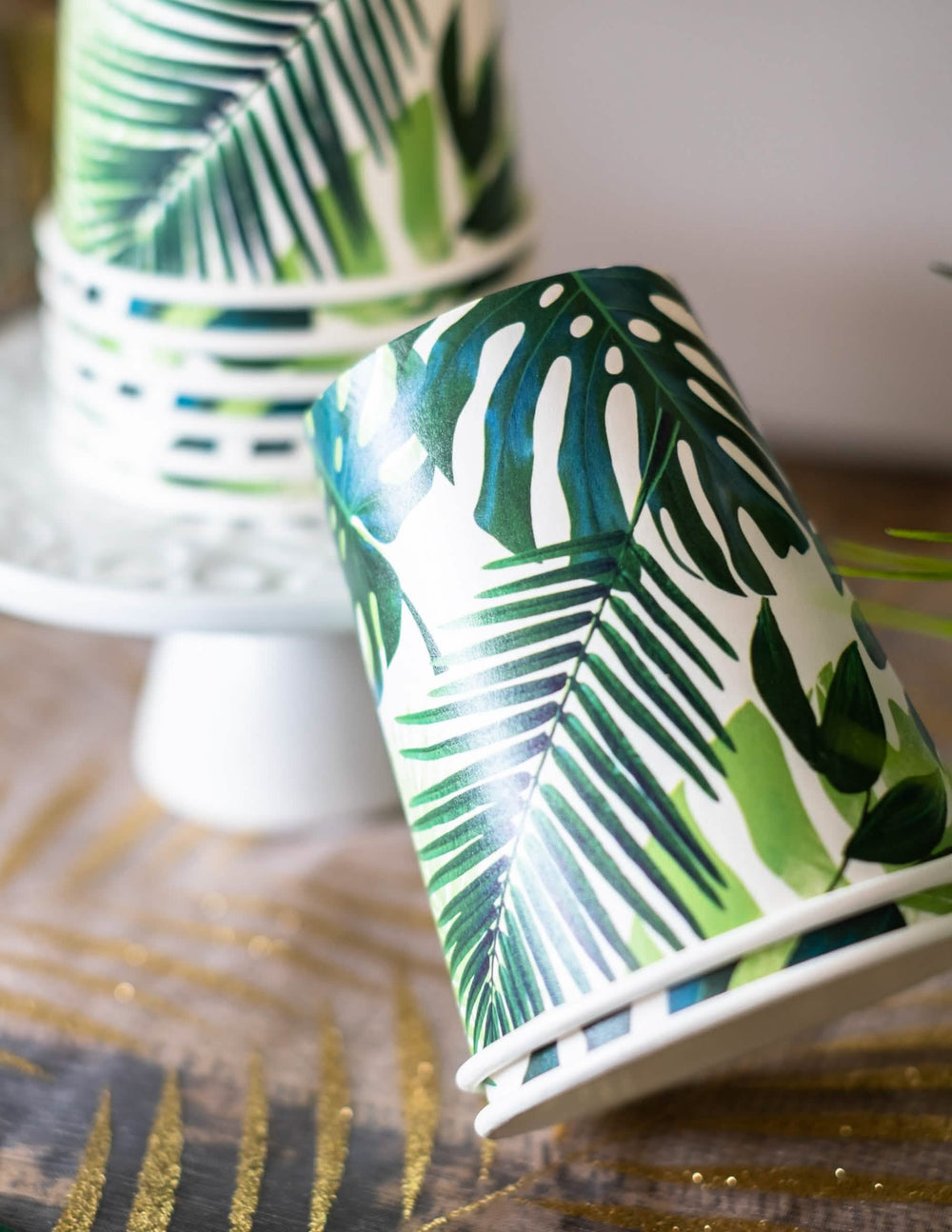 Detaliul modelului paharelor din carton tropical verde cu motive de frunze de palmier