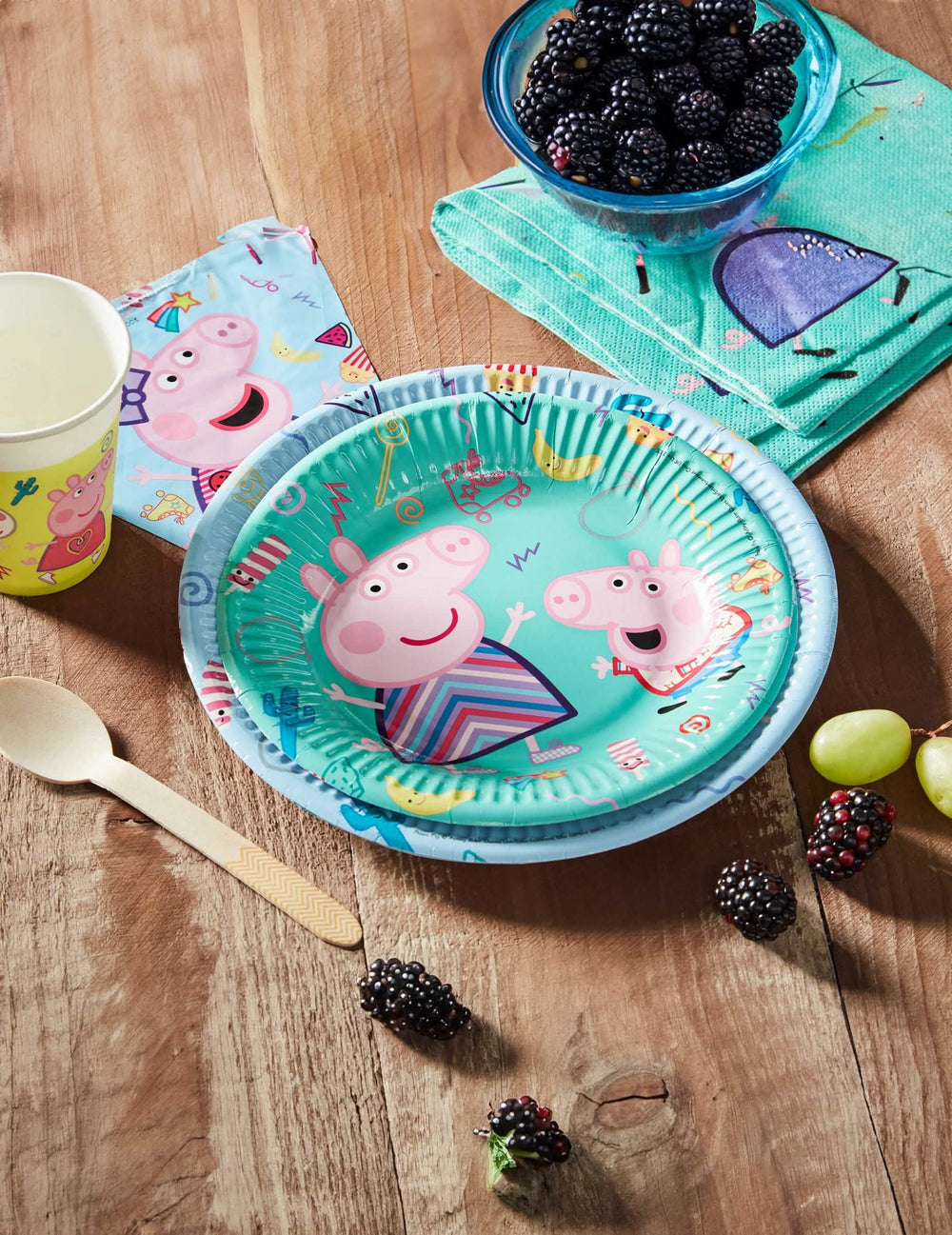 Aranjament pe o masă de petrecere cu farfurii mici de carton Peppa Pig