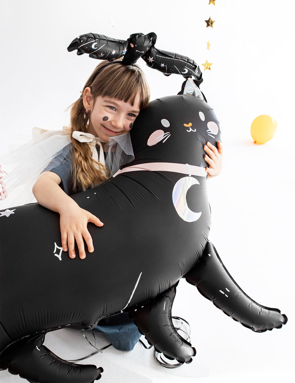 Enfant tenant dans ses bras le ballon aluminium chat noir pour Halloween